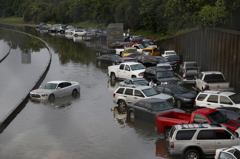 Vehicles left stranded on a flooded Interstate 45 in Houston, Texas on May 26, 2015.  Heavy rains throught Texas put the city of Houston under massive ammounts of water, closing roadways and trapping residents in their cars and buildings, according to local reports. Rainfall reached up to 11 inches(27.9cm) in some parts of the state, national forecasters reported, and the heavy rains quickly pooled over the state's already saturated soil. AFP PHOTO/AARON M. SPRECHER        (Photo credit should read Aaron M. Sprecher/AFP/Getty Images)