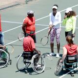 US tennis star Venus Williams (1stR) and her sister Serena Williams (2ndR) participate on November 3, 2012 in a two-hour tennis clinic with disabled children in wheelchairs at the Arthur Ashe Academy in Soweto.
