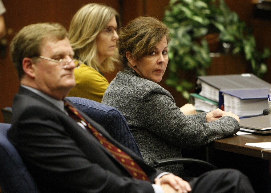 Former assistant city manager of Bell, Angela Spaccia, center, who is charged with misappropriation of public funds and other counts, listens to opening statements in Los Angeles Superior Court, Wednesday, Oct. 23, 2013.