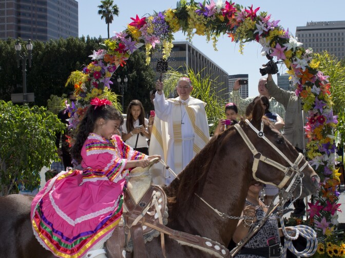 Anaii Gutierrez, 4, and her horse, Cara de Chango, receive a holy water blessing from Catholic Archbishop Jose H. Gomez during a Blessing of Animals Easter event in Los Angeles, California on April 4, 2015.