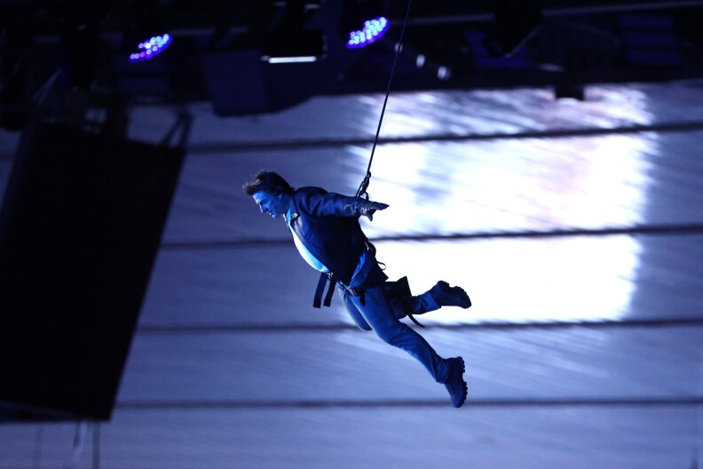 A man descend through the air on a wire.