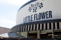 The exterior of Little Flower Candy Company café in Pasadena, showing the distinctive curved art deco storefront with "Little Flower" signage and black-and-white striped awning