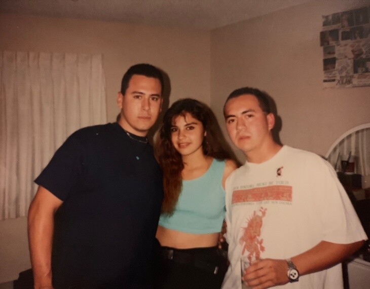 Three people in their late teens or early 20s pose together for a photo.