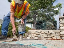 Larry Bender, of Northeast Graffiti Busters, cleans up graffiti on the streets of Highland Park on Tuesday, Aug. 11, 2015.