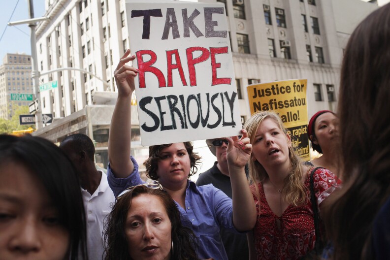 NEW YORK, NY - AUGUST 23:  Protesters stand outside of a Manhattan court as former IMF director  Dominique Strauss-Kahn exits the court on August 23, 2011 in New York City. The Manhattan District Attorney's office has filed a motion to dismiss the charges against Strauss-Kahn by Nafissatou Diallo, the hotel maid who accused Strauss-Kahn of sexual assault.  (Photo by Spencer Platt/Getty Images)