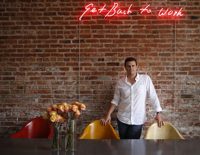 In this July 1, 2014 photo, Dollar Shave Club CEO and co-founder Michael Dubin poses for photos at the company's headquarters in Venice, Calif. The relocation of tech companies to southern California is part of a growing movement of U.S. cities seeking to duplicate the formula that turned northern California’s Silicon Valley, slightly south of San Francisco, into a mecca of society-shifting innovation and immense wealth. Dubin says the Venice scene has helped his online razor service recruit employees. 