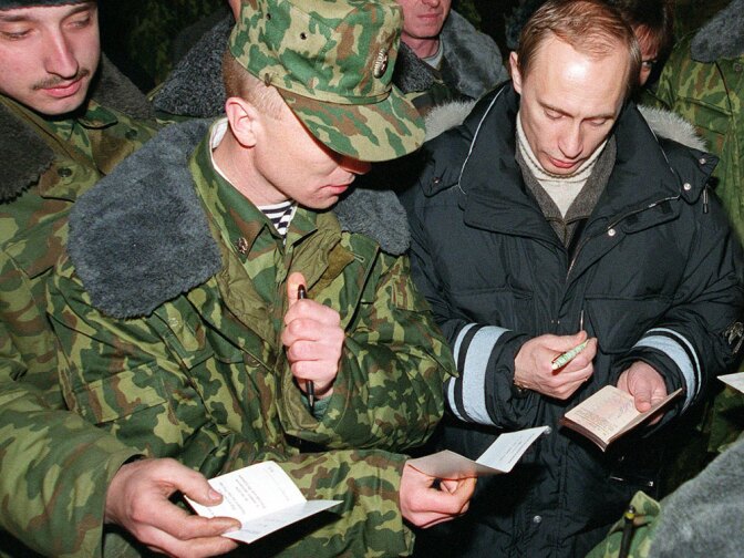 Then-acting Russian President Vladimir Putin signs autographs for Russian soldiers, east of the Chechen capital, Grozny, in January 2000. Putin, who took over office after President Boris Yeltsin resigned a day earlier, visited Russian forces in Chechnya to praise them for the campaign to crush separatist rebels.