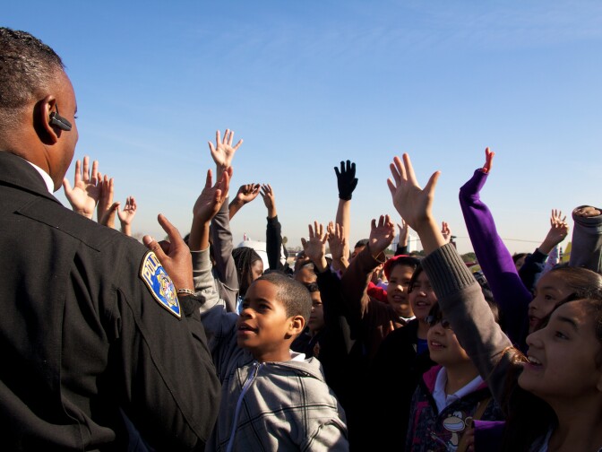 Students clamor to have Robin Petgrave choose them to help push a couple of planes forward.
