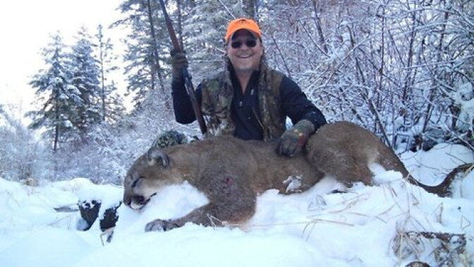 Richards poses with the now-dead mountain lion, which he later ate.