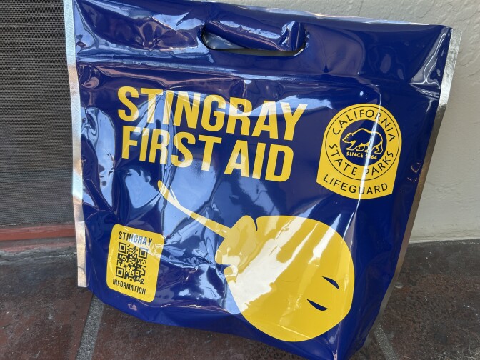 A navy blue bag with yellow lettering reading "STINGRAY FIRST AID" with a yellow drawing of a stingray and California state parks emblem. 