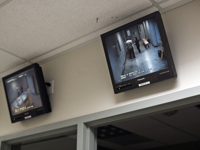 Mental health counselor Grace Bescoby and Officer Garett Bush of the Mental Evaluation Unit's SMART team talk with a man being held in custody at the LAPD's Rampart Division on Thursday, Dec. 11, 2014. The man was running through a multi-unit apartment building, screaming belligerently and threatening people with a stick.