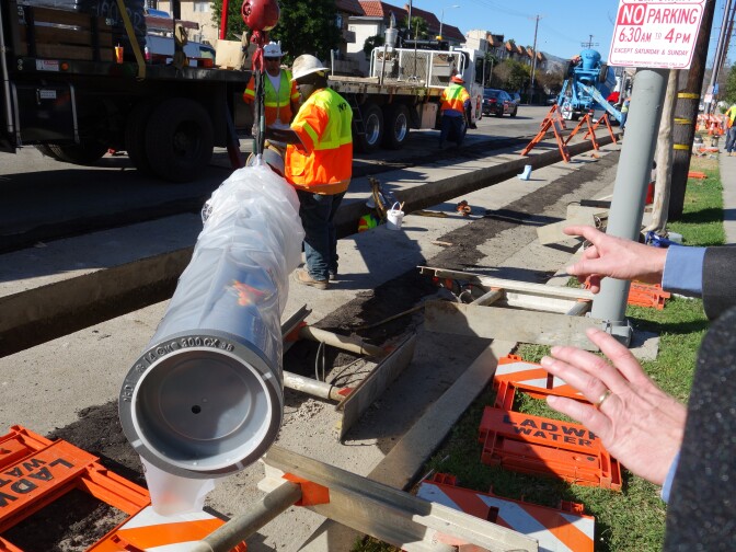 A length of earthquake-resistant pipe from Kubota Corp. of Japan is positioned over a trench on Reseda Blvd. Feb. 11, 2015