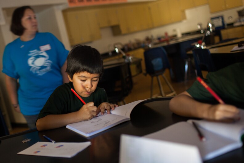 Fourth-grader Bryan Robledo designs a bridge during a summer science camp for that helps homeless children sponsored by Cal State Unversity - Long Beach.