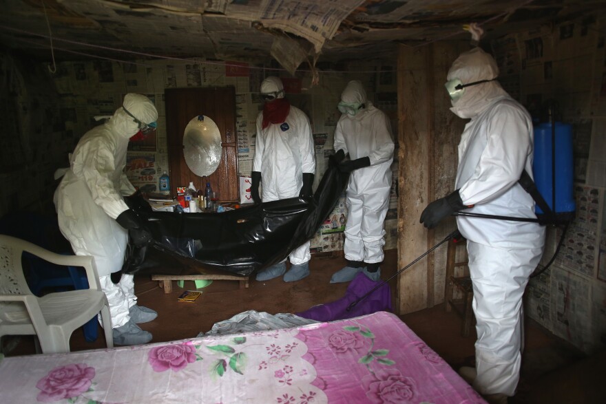 MONROVIA, LIBERIA - AUGUST 17:  A Liberian burial team, all wearing protective clothing, retrieves the body of a 60-year-old Ebola victim in his home on August 17, 2014 near Monrovia, Liberia. The virus has killed more than 1,000 people in four African countries, and Liberia now has had more deaths than any other country.  (Photo by John Moore/Getty Images)