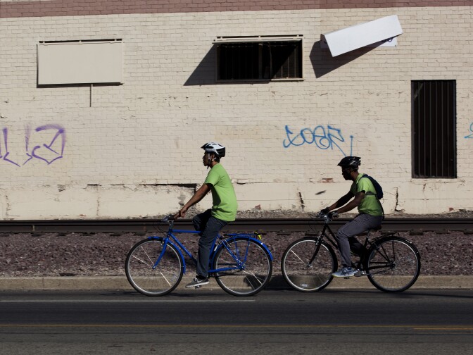 Victor Aquino and Malcolm Harris bike along Slauson Avenue, navigating traffic and unsafe conditions.