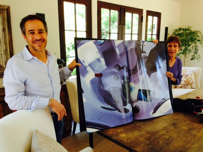 Josh and Rheta Resnick holding up a picture book given to them after they reserved tickets for Virgin Galactic's space flight. Josh bought the tickets 7 years ago and he says he doesn't mind the wait since it gives him time to anticipate the adventure.