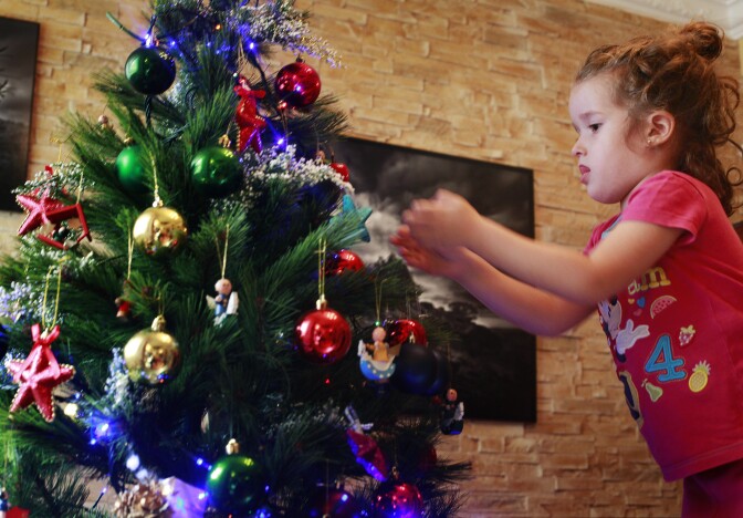 Four-year old Vera Martin prepares the Christmas tree at her home on the island of Tenerife on December 8, 2013.