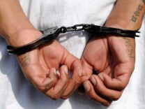 LOS ANGELES, CA - APRIL 29:  Handcuffs are seen on the hands of a twenty-year old "Street Villains" gang member who was arrested by Los Angeles Police Department officers from the 77th Street division on April 29, 2012 in Los Angeles, California. The 77th Street division patrol the same neighborhood that truck driver Reginald Denny was nearly beaten to death by a group of black assailants at the intersection of Florence and Normandie Avenues. It’s been 20 years since the verdict was handed down in the Rodney King case that sparked infamous Los Angeles riots.  (Photo by Kevork Djansezian/Getty Images)