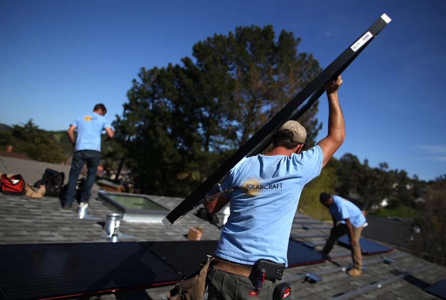 SAN RAFAEL, CA - FEBRUARY 26:  SolarCraft worker Joel Overly carries a solar panel on the roof of a home on February 26, 2015 in San Rafael, California. According to a survey report by the Solar Foundation, the solar industry employs more workers than coal mining with nearly 174,000 people working in solar compared to close to 80,000 mining coal.  (Photo by Justin Sullivan/Getty Images)