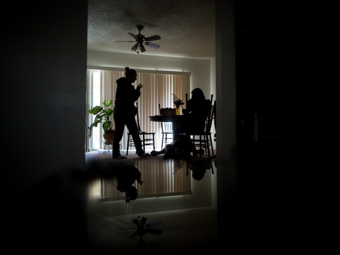 Marth, Damian's mother, speaks with a counselor about her son's mental health in the family's Pomona dining room.