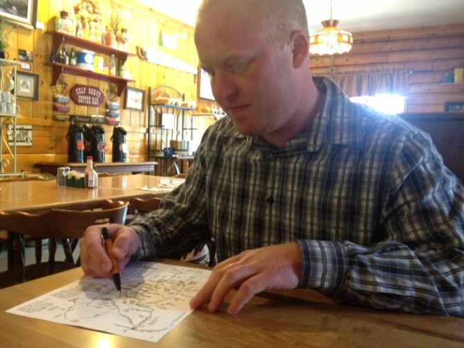 Brent Berens, from The Oaks Restaurant, marks the location of the cabin where Christopher Dorner died near Big Bear on a hand-drawn map of the Angelus Oaks area. 