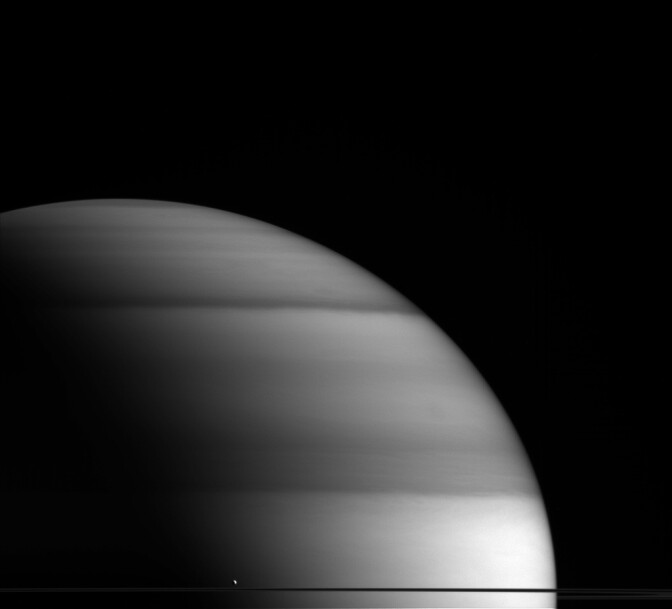 Enceladus, Saturn's sixth largest moon, floats amongst the gas giant's rings.