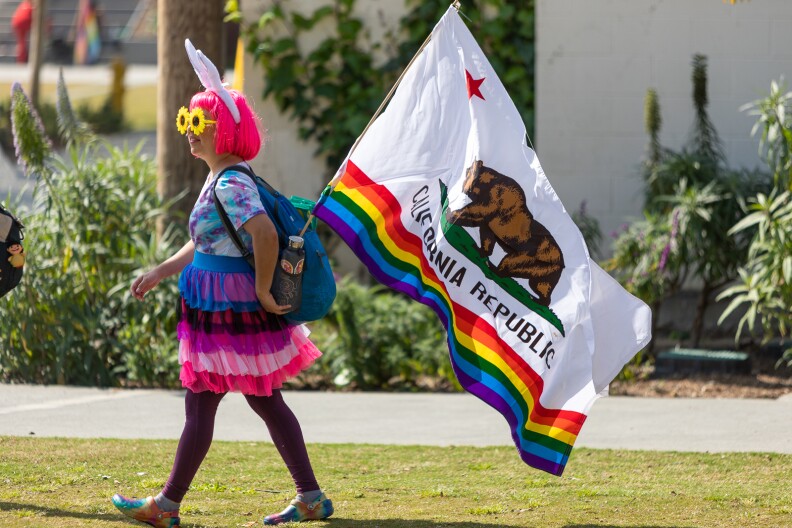A protester carries a California State Pride flag at the Los Angeles Drag March in West Hollywood on Sunday.