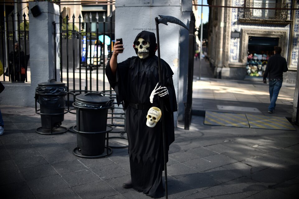 Death may not take a holiday but it does take a selfie. A man is dressed up for an exhibition of altars organized by the Historic Centre Foundation for Day of the Dead in Mexico City on November 1, 2016.