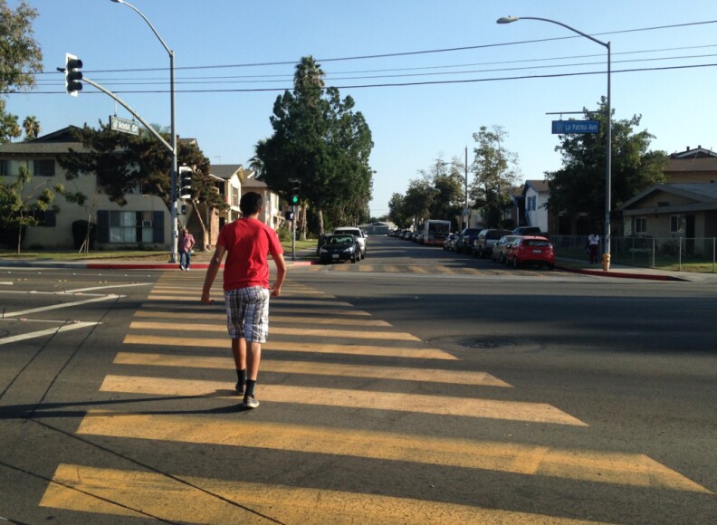 Pedestrians cross La Palma Avenue at Anna Drive in Anaheim. A police-involved shooting on Anna Drive several years ago led to violent protests in this city, where some say is divided into richer and poorer areas.