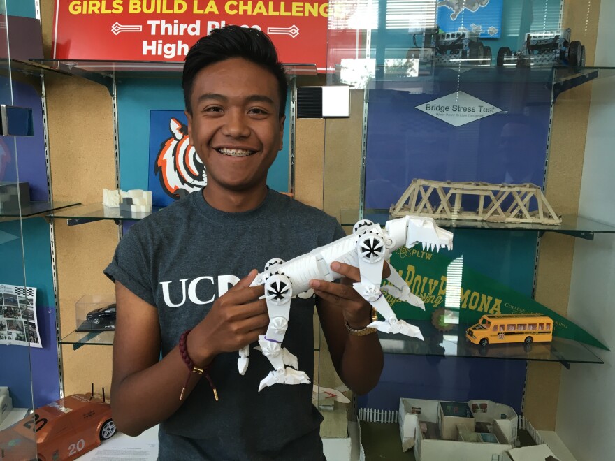José Rodríguez, 17, a senior at STEAM Legacy High School in South Gate, poses with a 3D-printed model of the school's mascot, the "Tigerbot." He plans to attend UC Berkeley in the fall.