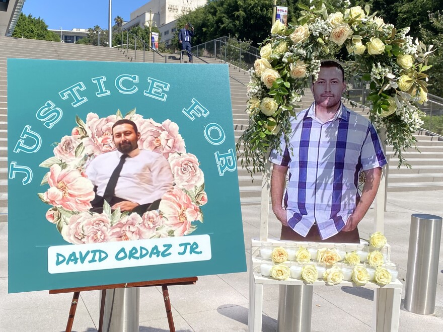 Two posters honoring David Ordaz Jr. were displayed outside the federal courthouse Thursday. The left poster features a picture of Ordaz, Jr. with text that reads "Justice for David Ordaz, Jr." The poster on the right shows Ordaz standing and has a wreath of flowers around it.