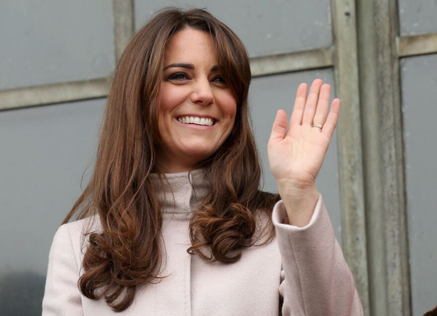 Catherine, Duchess of Cambridge smiles and waves to the crowds from the balcony of Cambridge Guildhall as she pays an official visit to Cambridge with Prince William, Duke of Cambridge on November 28, 2012 in Cambridge, England.