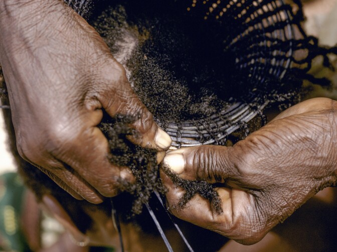 Weaving a traditional Mangbetu hairstyle in 1970, Medje village, Congo.