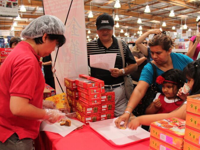 But I want that slice! Costco customers in Alhambra reach out to grab a slice of a moon cake.