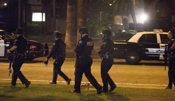 Police respond in Riverside, Calif., early Thursday morning, Feb. 7, 2013, after one officer was killed and another critically wounded in a shoot out with a murder suspect.  Police were searching for a former Los Angeles police officer sought for two weekend killings — and who threatened to kill police.   