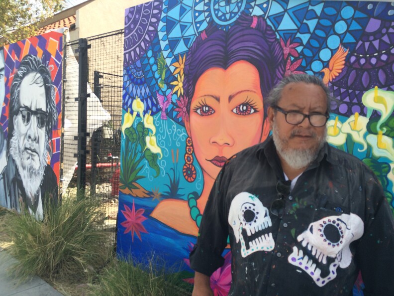 Artist Manny Velazquez, 56, stands in front of an unfinished mural in Pacoima which tells the history of the place and community. Velazquez says it's part of efforts to transform the neighborhood into a safe, community-centered place to live.