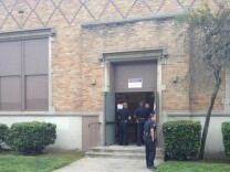 LAPD officers investigate the shooting of a poll worker at 92nd Street Elementary School. Police say the man was shot by his girlfriend and is expected to survive.