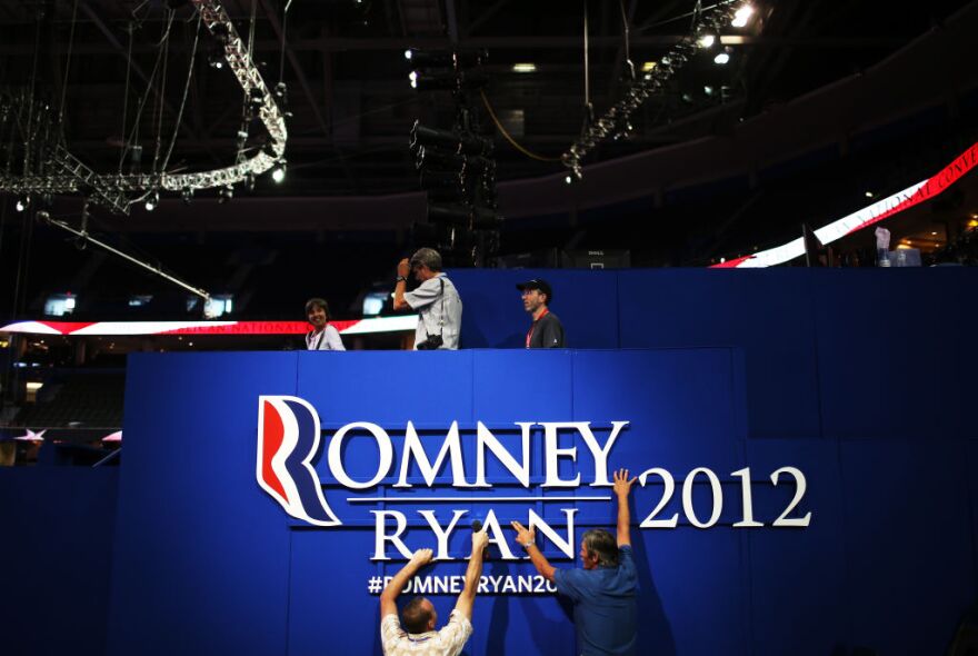TAMPA, FL - AUGUST 26:  Two workers hang a sign ahead of the Republican National Convention at the Tampa Bay Times Forum on August 26, 2012 in Tampa, Florida. The RNC is scheduled to convene on August 27 and will hold its first session on August 28 as Tropical Storm Isaac threatens disruptions due to its proximity to the Florida peninsula.  (Photo by Chip Somodevilla/Getty Images)