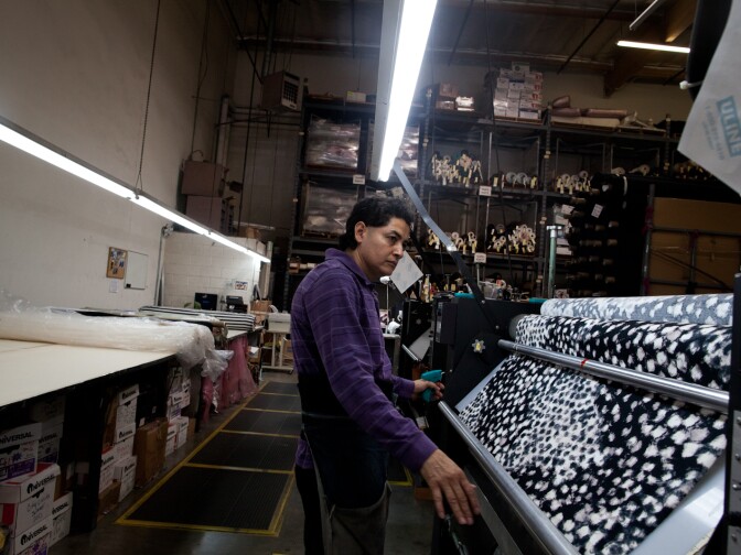 Jose Luis Garcia inspects for variations and holes in fabric before it's sent to production.