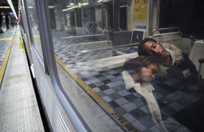 LOS ANGELES, CALIFORNIA - APRIL 01:  People rest while riding a Los Angeles Metro Rail train amid the coronavirus pandemic on April 1, 2020 in Los Angeles, California. As of last week, L.A. Metro ridership was down an estimated 81 percent on rail and 68 percent on buses amid the spread of COVID-19. L.A. Metro’s trains and buses are cleaned daily and the agency is now encouraging riders to social distance and only board for ‘essential’ trips.  (Photo by Mario Tama/Getty Images)