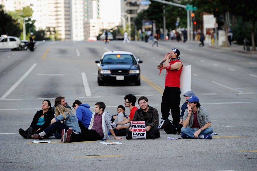 LOS ANGELES, CA - NOVEMBER 09:  Eleven UCLA students sit in a circle in the intersection of Westwood and Wilshire boulevards as part of a protest of bank practices and rising fees at public universities before they were arrested by are arrested by Los Angeles Police Department on November 9, 2011 in Los Angeles, California. The protest organized by ReFund California was one of several planned at universities around the state.  (Photo by Kevork Djansezian/Getty Images)