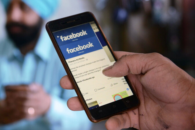 An Indian man looks at the Facebook app on his smartphone in Amritsar on March 22, 2018. / AFP PHOTO / NARINDER NANU        (Photo credit should read NARINDER NANU/AFP via Getty Images)