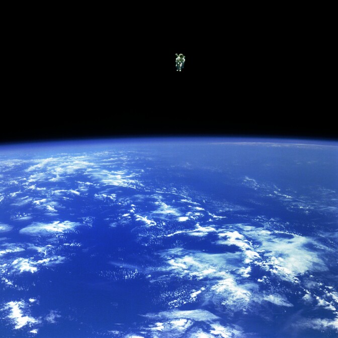 Mission Specialist Bruce McCandless II, is seen further away from the confines and safety of his ship than any previous astronaut has ever been. This space first was made possible by the Manned Manuevering Unit or MMU, a nitrogen jet propelled backpack. After a series of test maneuvers inside and above Challenger's payload bay, McCandless went "free-flying" to a distance of 320 feet away from the Orbiter. This stunning orbital panorama view shows McCandless out there amongst the black and blue of Earth and space.

Credit: NASA