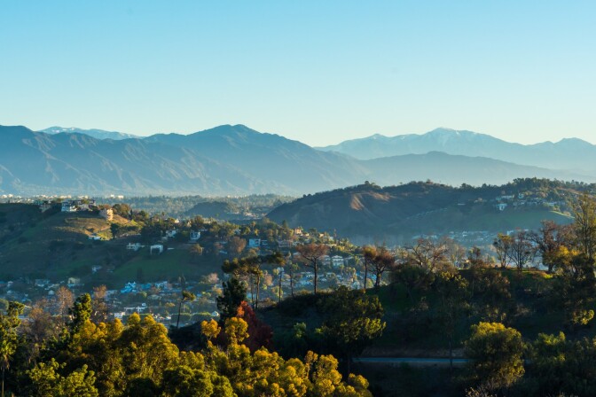 An image of foothills and houses in the San Gabriel Valley with a mountain range in the background.