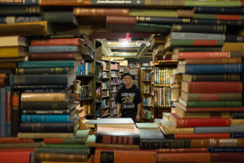 a shot of a person through a stack of books