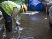 Chad Newlee, a line patrol mechanic for Los Angeles Department of Water and Power, works to pump water out of the back of an apartment building in order to check electric panels after an 18-inch main burst in Hollywood early Wednesday morning, Feb. 18, 2015 releasing a torrent of water onto residential streets and submerging cars.