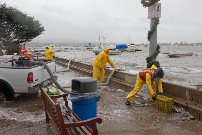 Newport Beach workers pump water that overtopped the seawalls on Balboa Island on Dec. 22, 2010. High tides and storm surges occasionally cause flooding on the island, but sea level rise threatens to make it a more frequent phenomenon. The city plans to extend the island's seawalls by 9 inches as a short-term fix. 