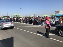 Passengers cluster together, waiting for Lyft rides at LAX's new rideshare pickup zone, Oct. 29, 2019. 