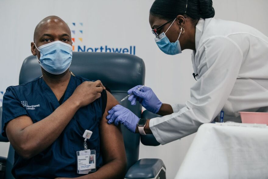 NEW YORK, NY - DECEMBER 14: Lenox Hill Hospital Chair of Emergency Medicine Yves Duroseau receives the COVID-19 vaccine at Long Island Jewish Medical Center on December 14, 2020 in New Hyde Park on Long Island, New York. The first vaccination was administered to a frontline healthcare worker Monday, with Governor Andrew Cuomo attending the event remotely. (Photo by Scott Heins/Getty Images)