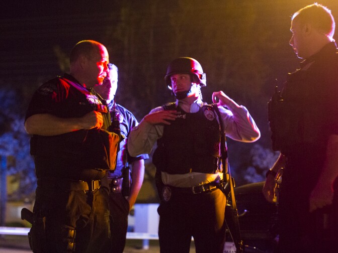 Redlands Police stand on Center Street near Pine Avenue on Wednesday night, Dec. 2, 2015 as authorities serve a search warrant following a mass shooting inside the the Inland Regional Center in San Bernardino on Wednesday, Dec. 2, 2015.